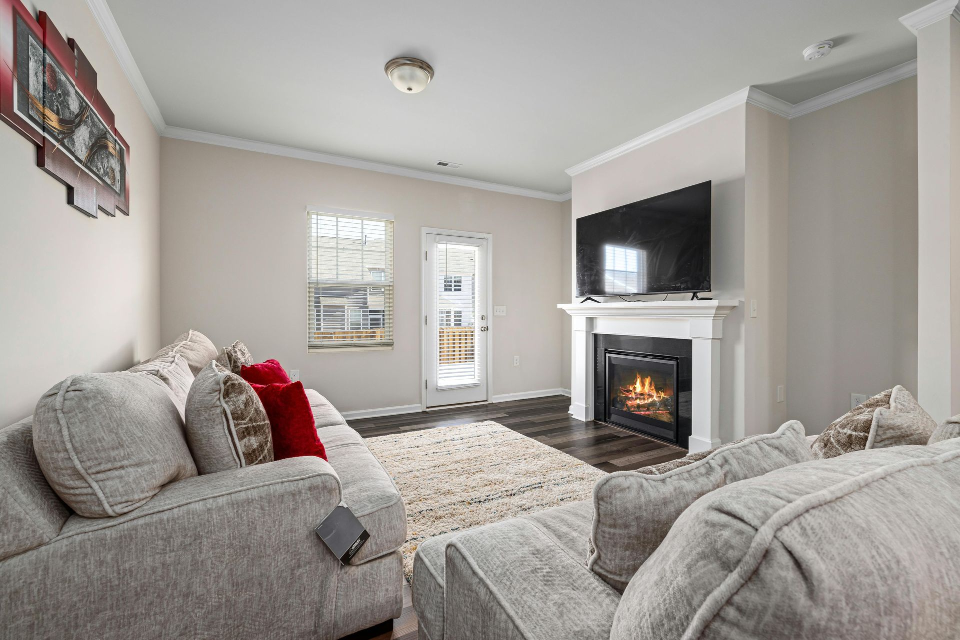 Cozy modern living room featuring a stylish fireplace and large TV for ultimate relaxation.