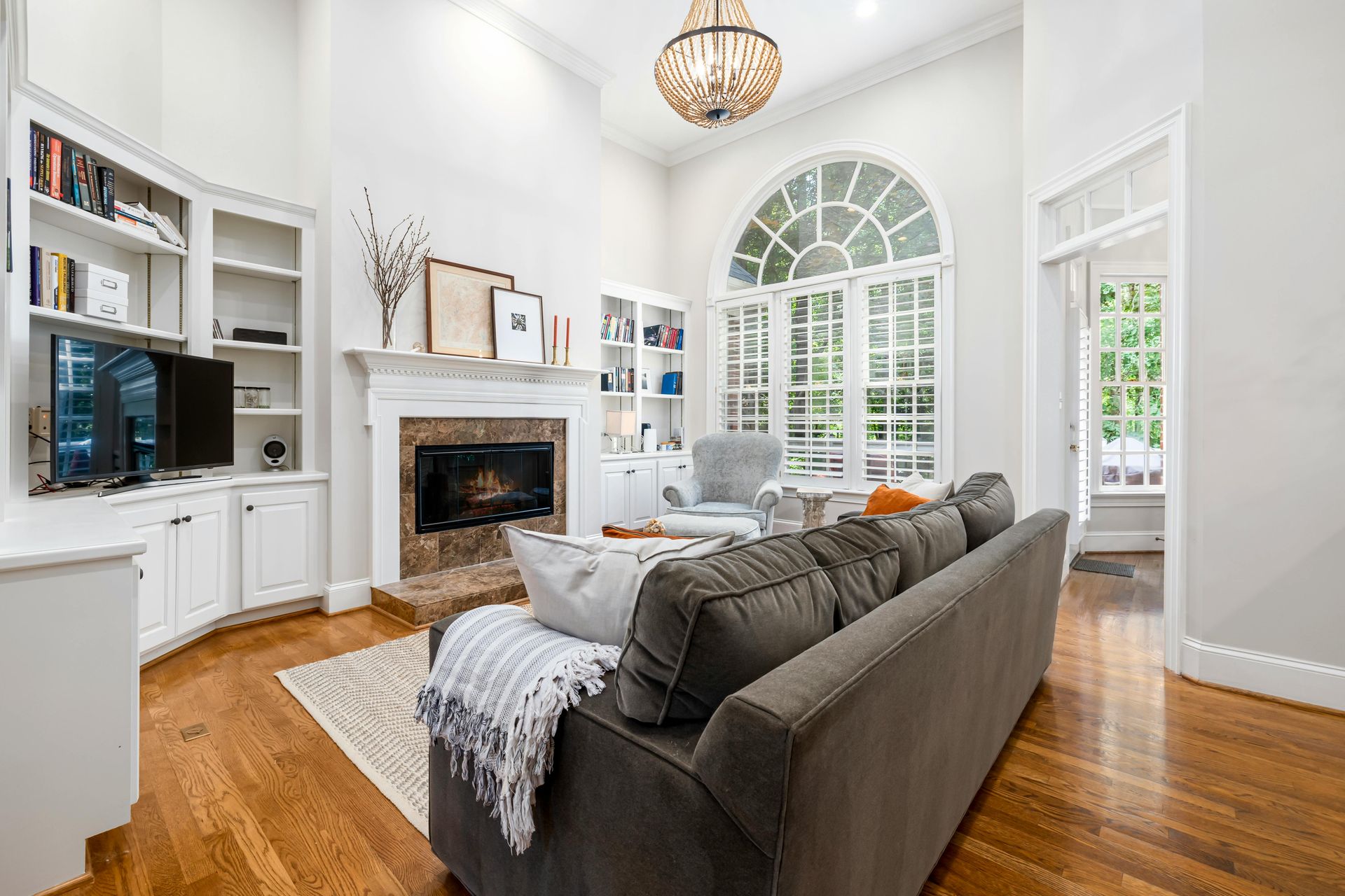 Spacious living room featuring modern decor, fireplace, and large window.